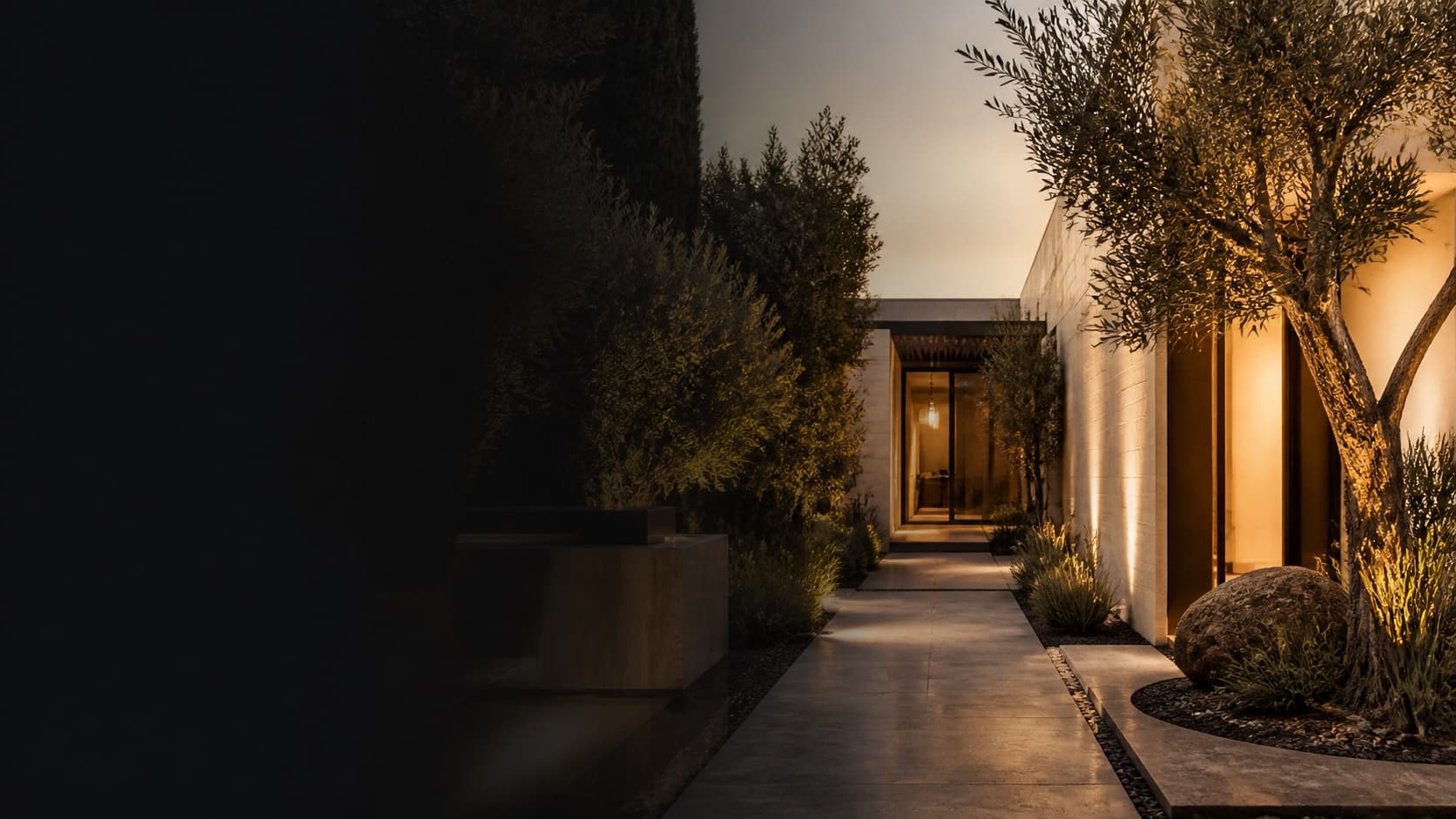 An illuminated modern Los Angeles courtyard with a pathway leading to the entry